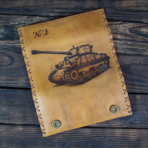 Handmade tan leather tobacco pouch with engraved tank design, decorative stitching and metal snap closures.